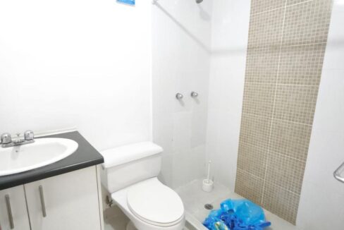 Baño completo con ducha y cenefa de mosaico en casa en venta en Pomasqui, Quito