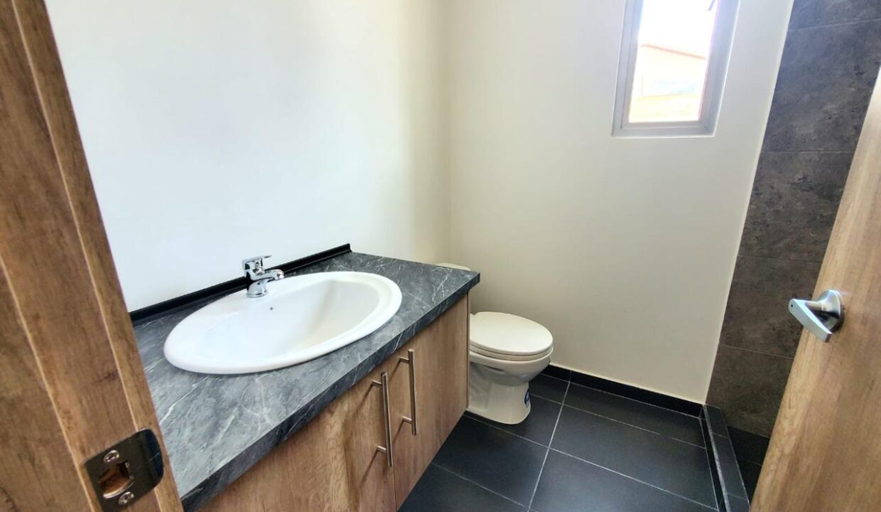 Baño social con mesón de granito en casa en venta en Pomasqui, Quito