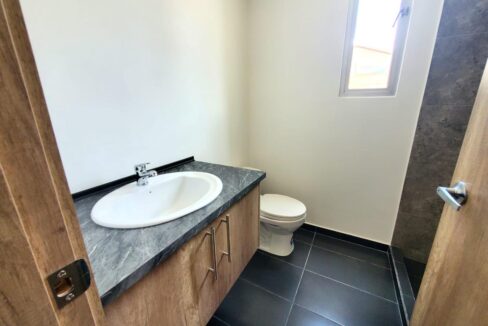 Baño social con mesón de granito en casa en venta en Pomasqui, Quito