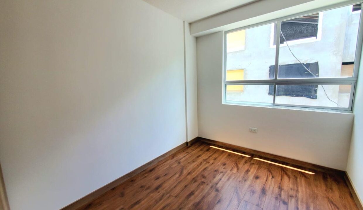 Dormitorio con piso flotante y ventanal en casa en venta en Pomasqui, norte de Quito