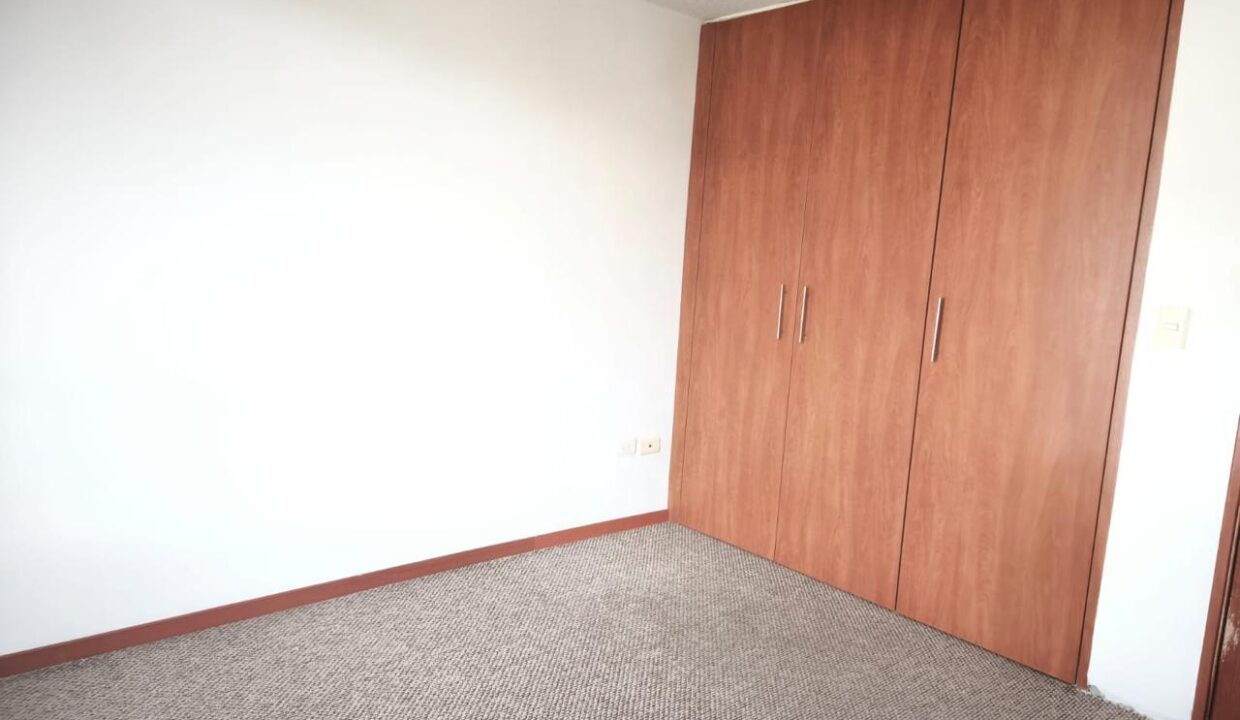 Dormitorio con closet empotrado en casa de 3 pisos en Pomasqui, Quito