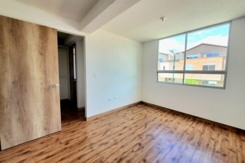 Dormitorio máster con walking closet y ventanal amplio en Pomasqui, Quito
