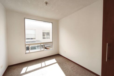 Dormitorio con ventanal y buena iluminación en casa en Pomasqui, Quito
