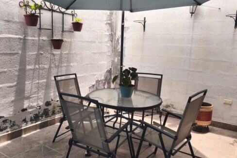 Patio posterior con zona de estar en casa en venta en Pomasqui, Quito