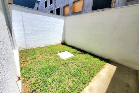 Patio posterior con jardín de la casa en venta en Pomasqui, Quito