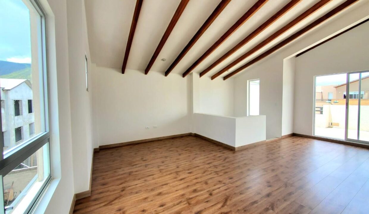 Tercer piso con vigas de madera vistas y salida a terraza en Pomasqui, Quito