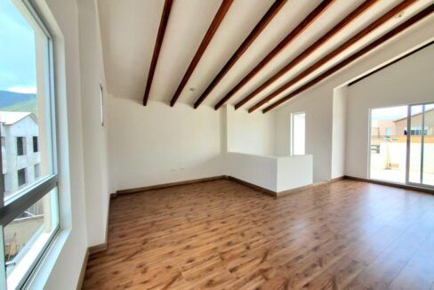 Tercer piso con vigas de madera vistas y salida a terraza en Pomasqui, Quito